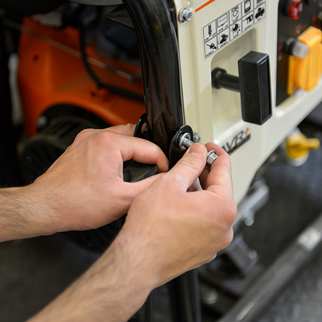 mains qui mettent en place la poignée du groupe électrogène MECAFER MF 4800 HD