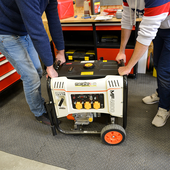 Groupe électrogène MECAFER MF 4800 HD porté par deux hommes