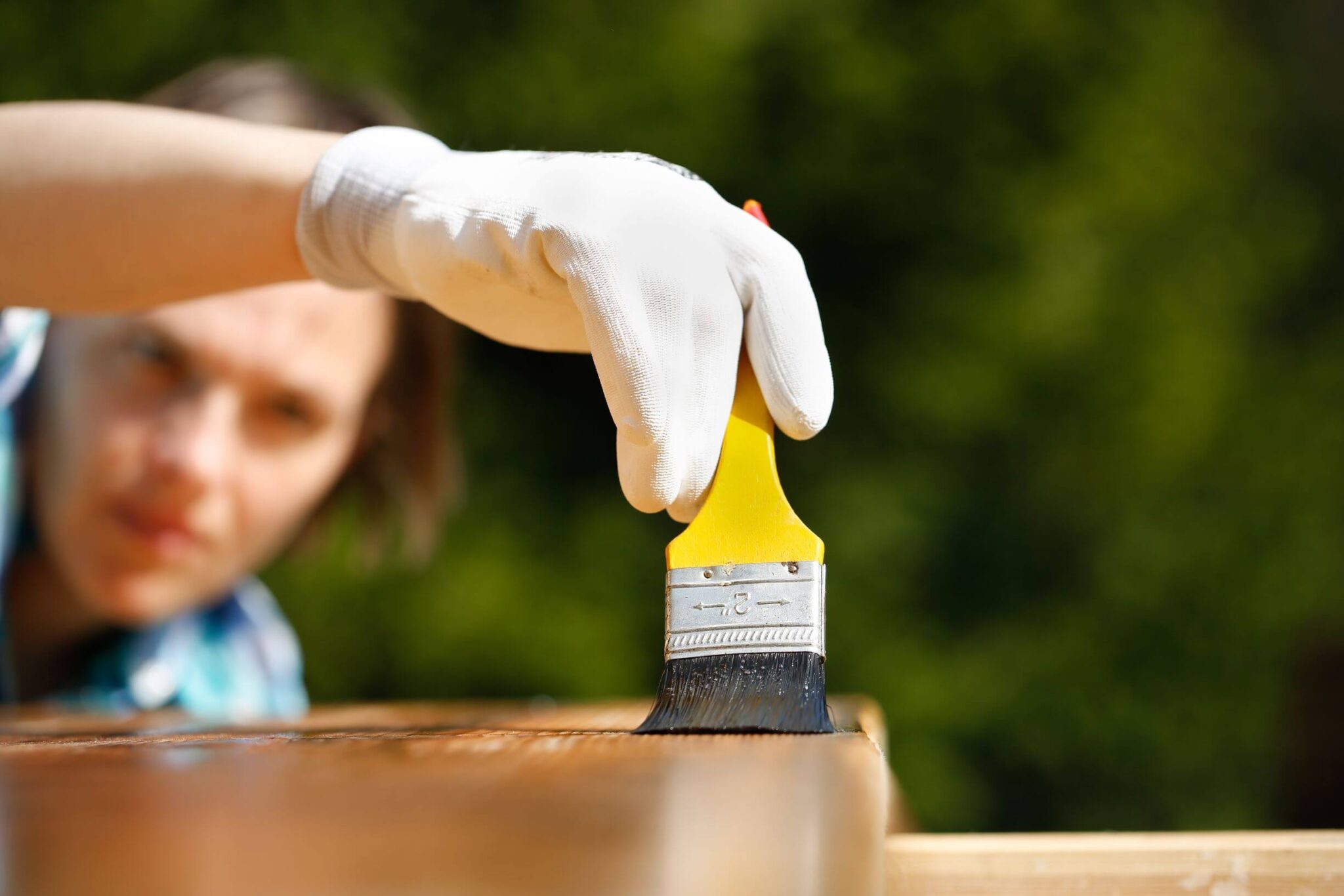 une personne entretien sa terrasse bois