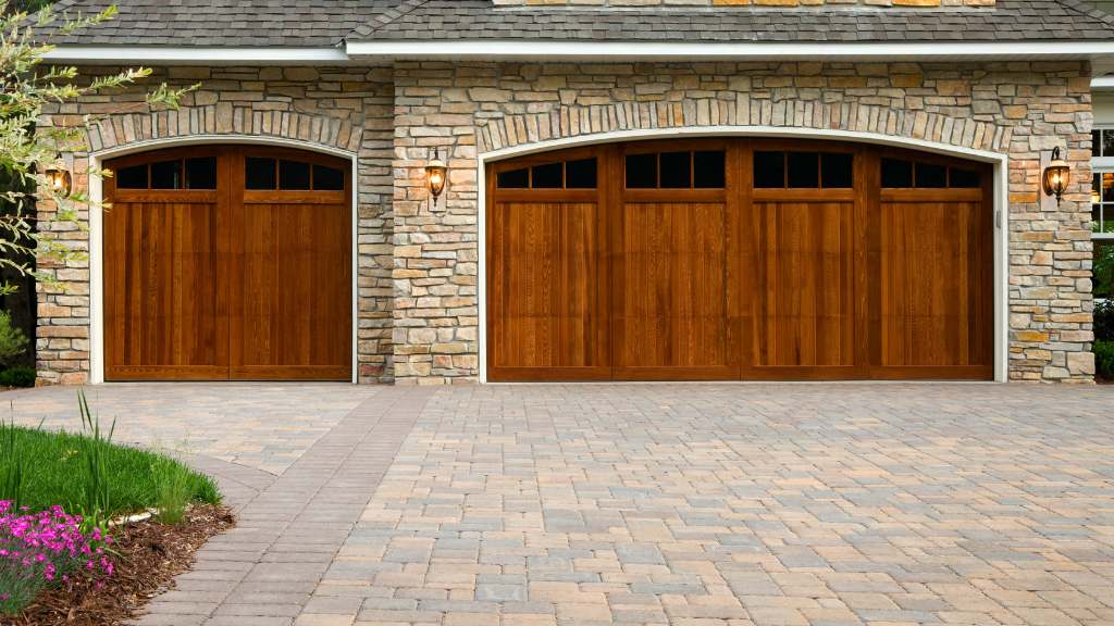 Cour d'une maison pavée et portes de garage en bois